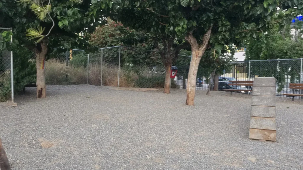 Σκιερός χώρος με δέντρα, παγκάκια και περίφραξη στο dog park στο Σεραφείο